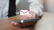 male holding iphone checking email